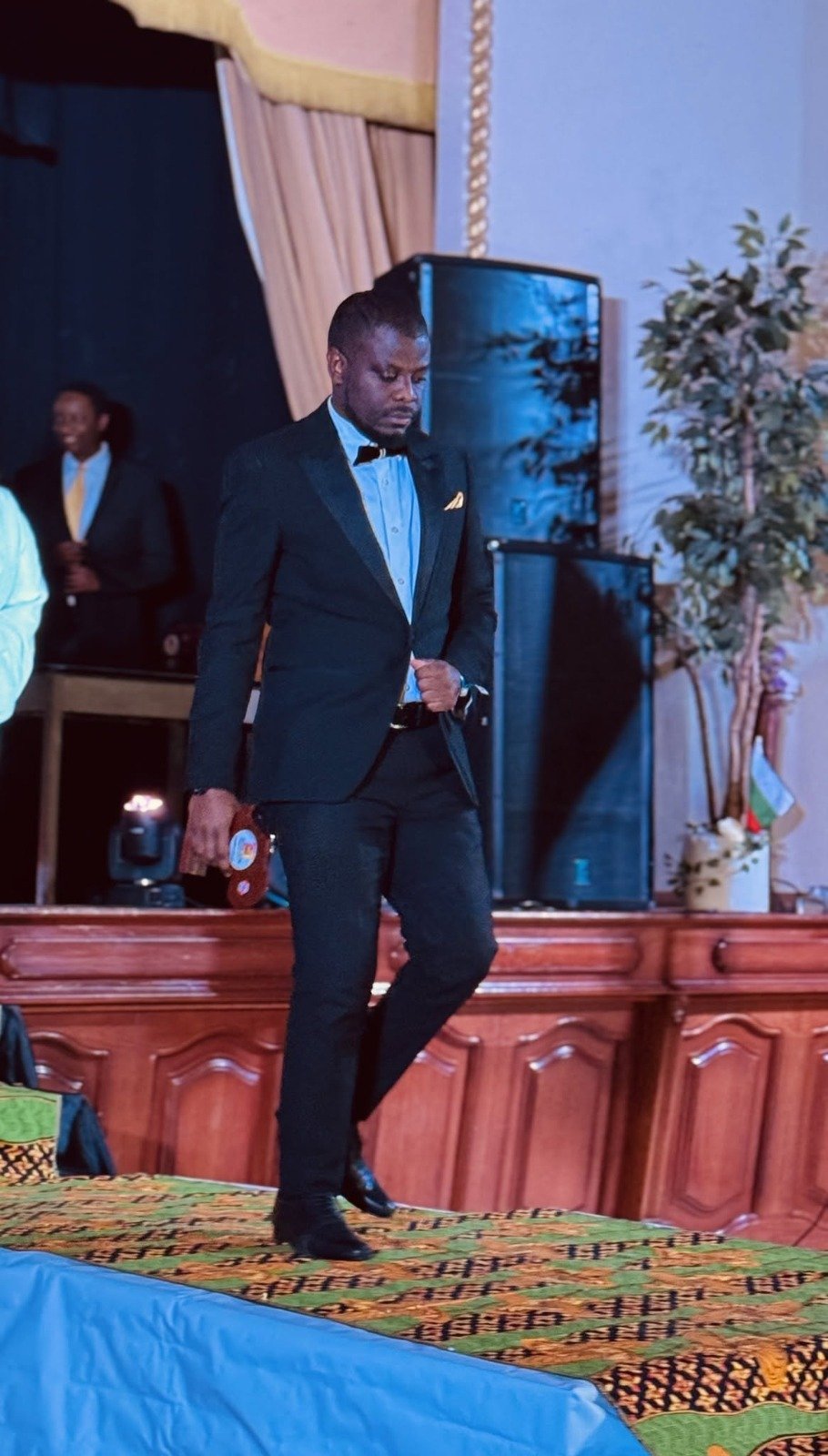 Alex Ahabwe leaving a stage after a professional engagement